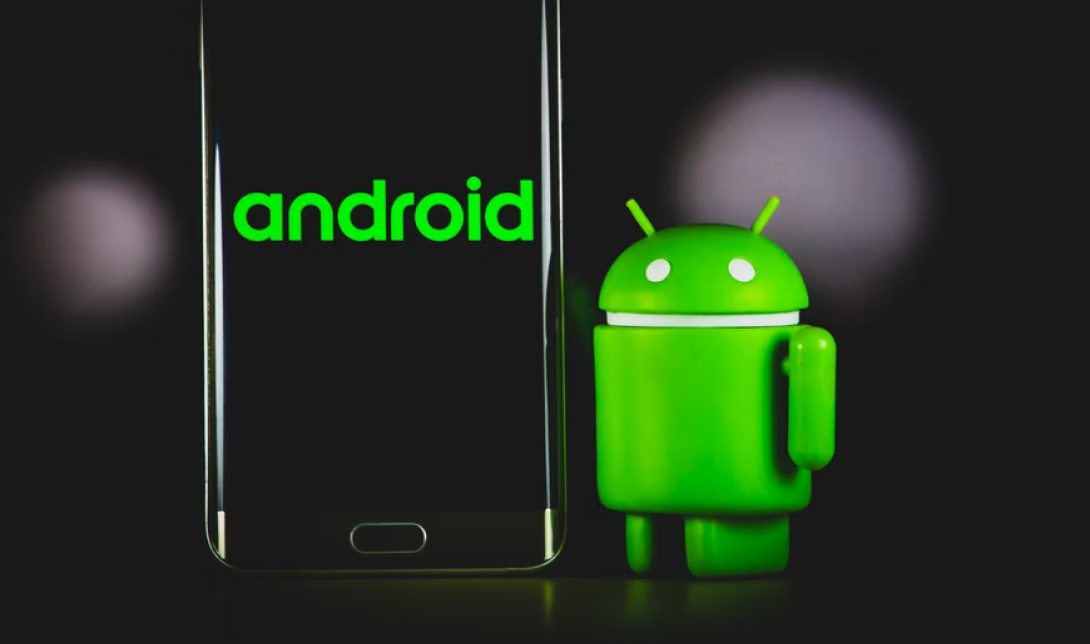 Android Mascot Standing Next To Android Phone